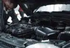 man in white shirt standing beside black car